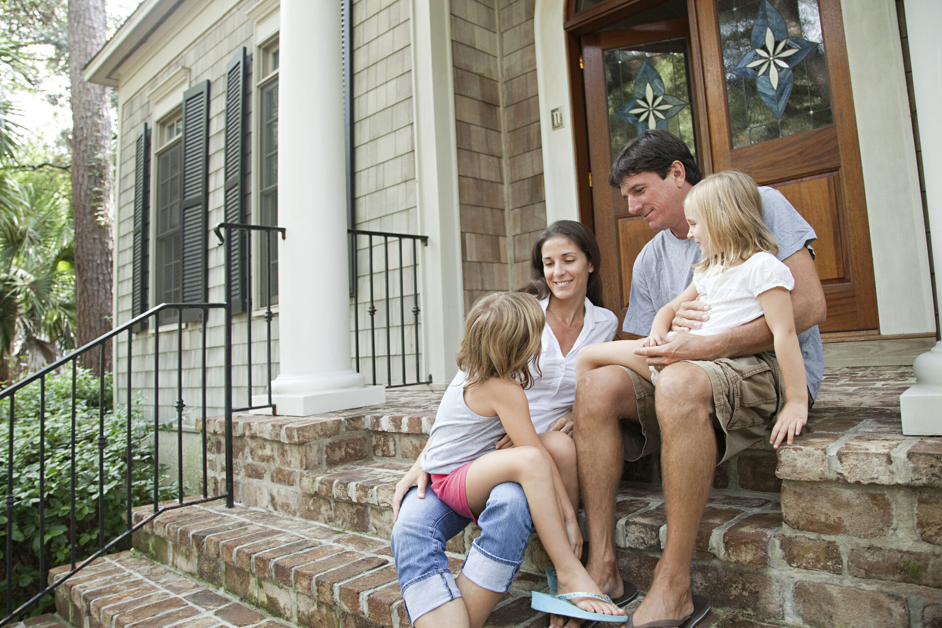 Family sitting together on front porch steps
